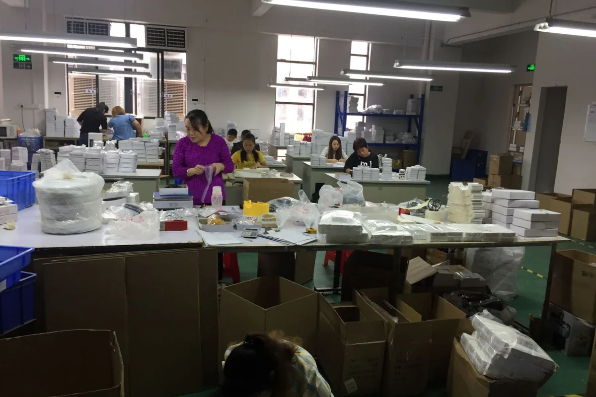 Operators working at several stations in a production workshop.