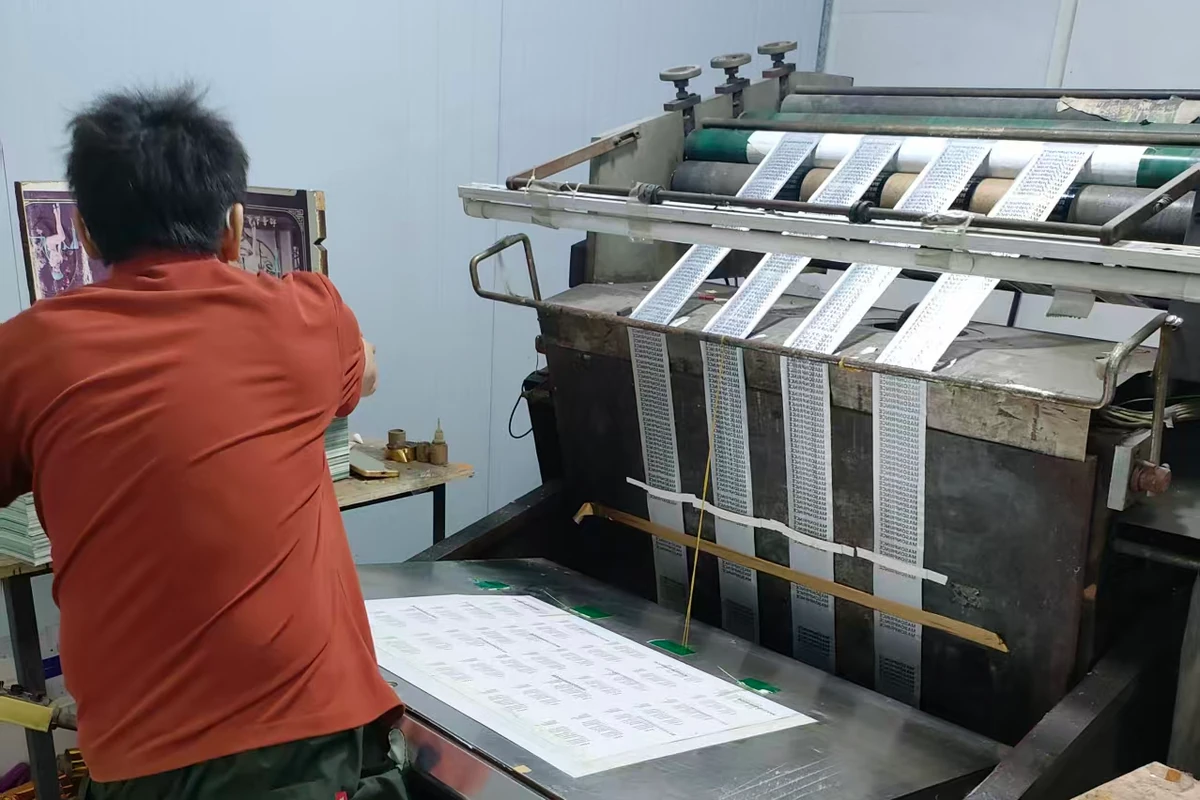 An operator preparing a sheet at a printing machine.