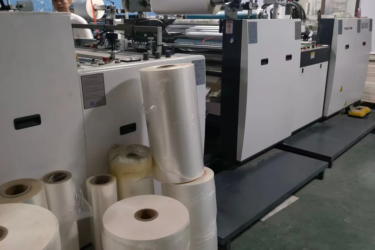 Printing equipment with rolls and stacks of material.