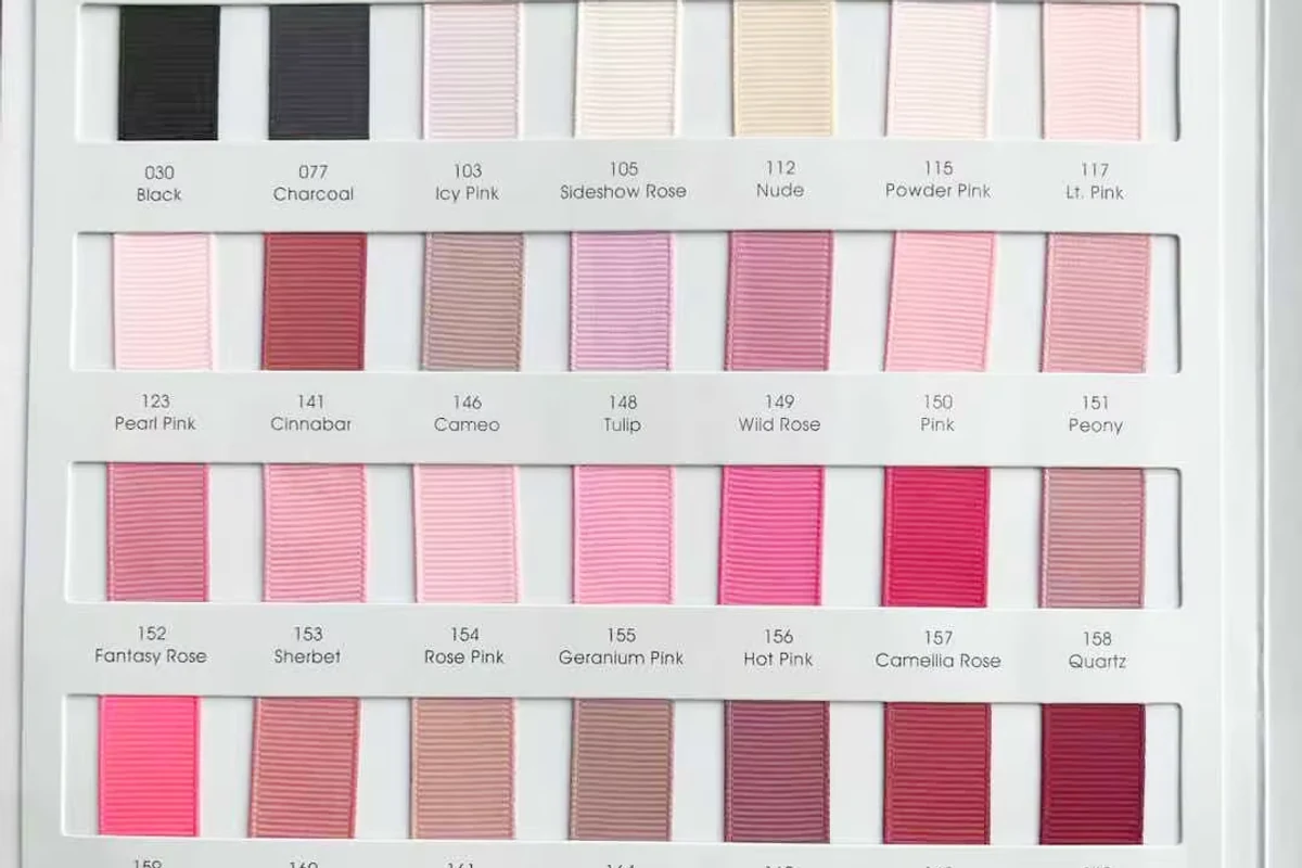 Close-up of light, pink, and red ribbon material swatches.