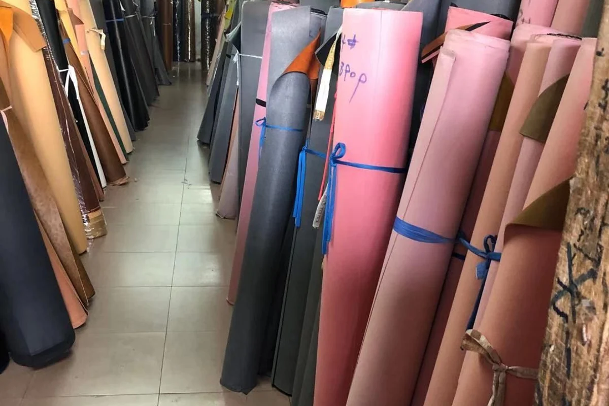 Material rolls in several colors stored upright.