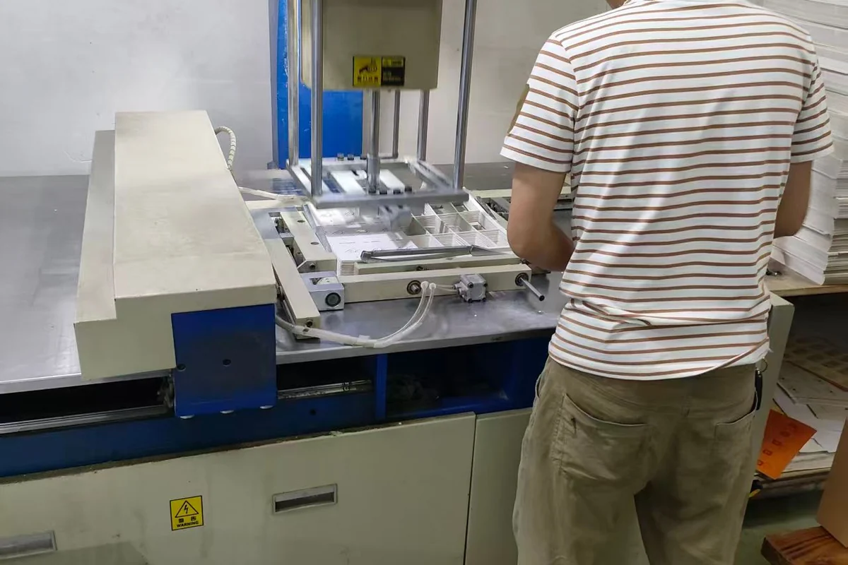 An operator handling printed paper at a finishing station.