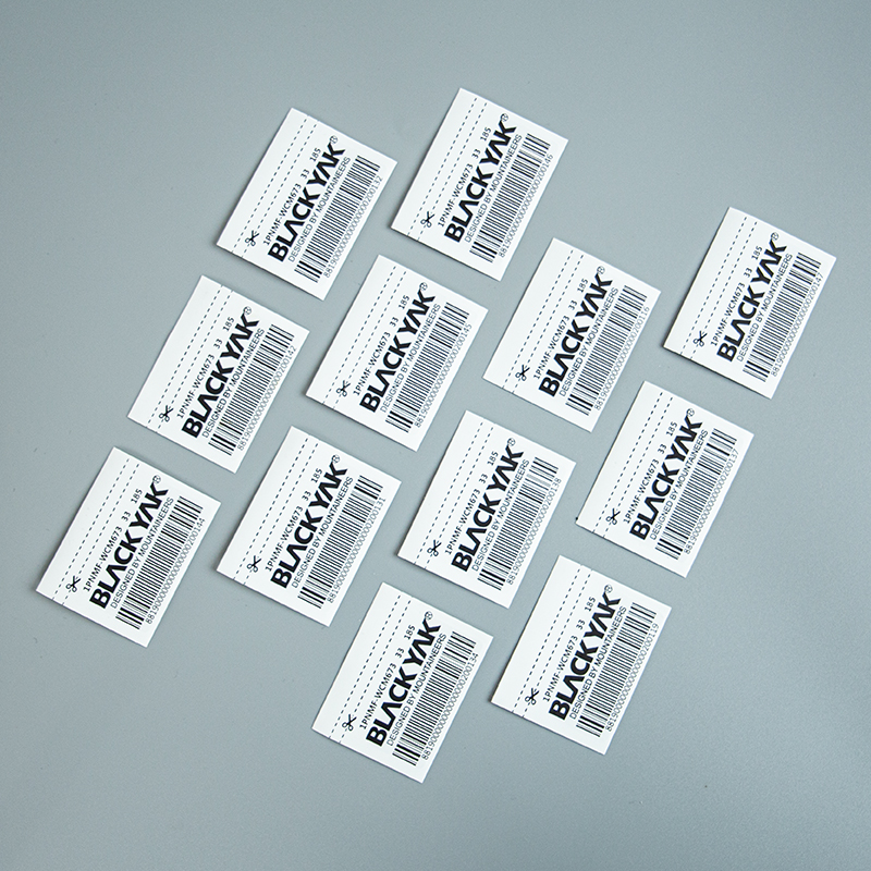White rectangular label samples printed with a brand name and linear barcodes.