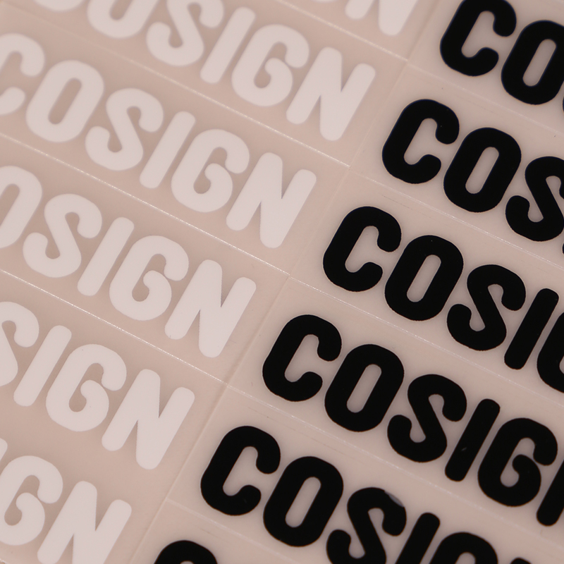 Rows of black and white lettering heat transfers on carrier sheets.