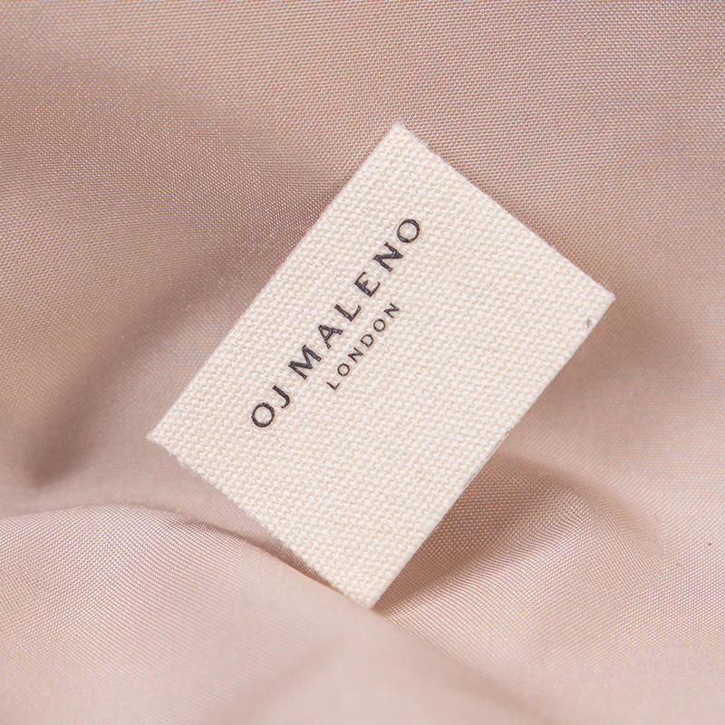 Cream fabric label with a black printed wordmark.