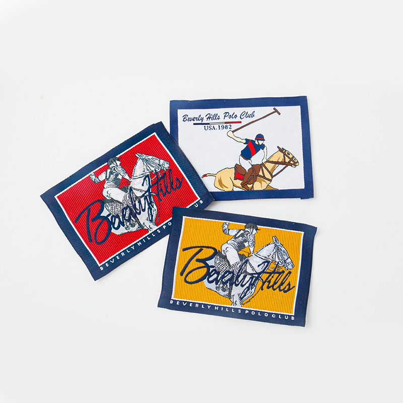 Three multicolor woven label samples with framed artwork and lettering.