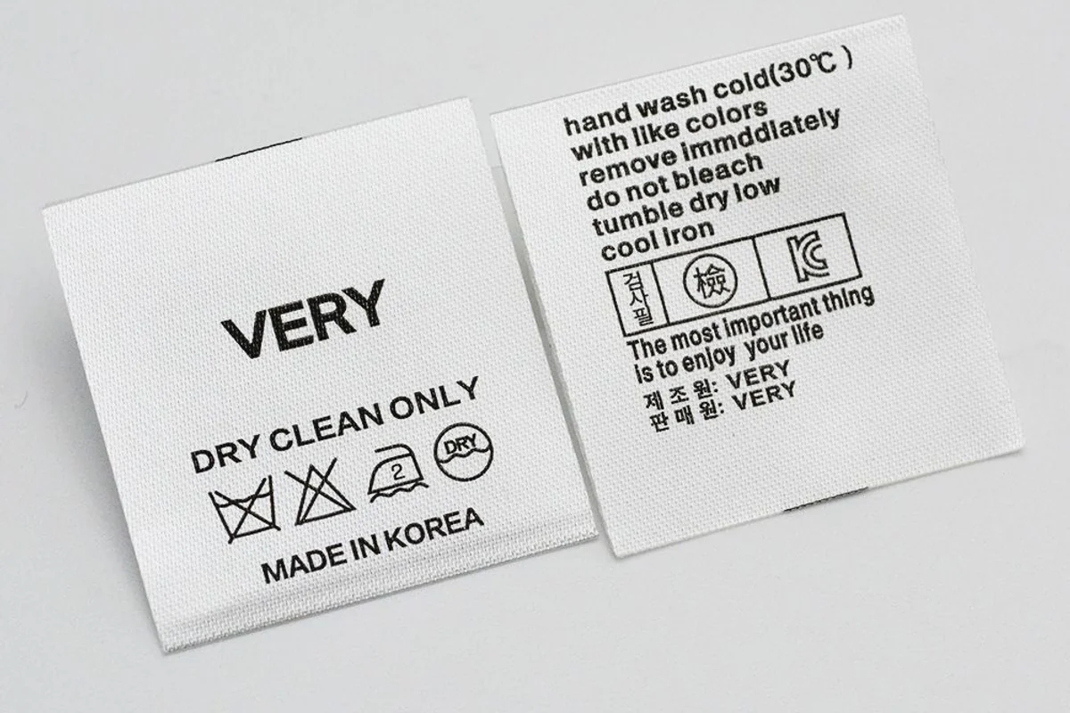 White care-label faces with printed wording and washing symbols.