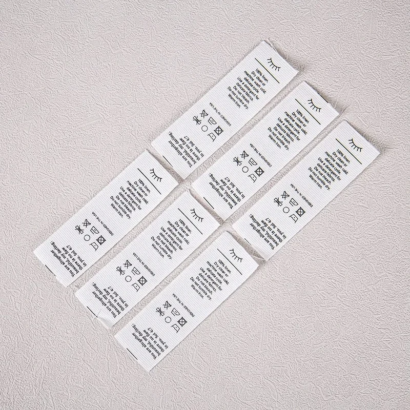 Several finished care label samples with printed washing information.