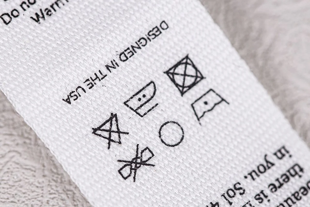 Close view of printed care information on a woven fabric label.