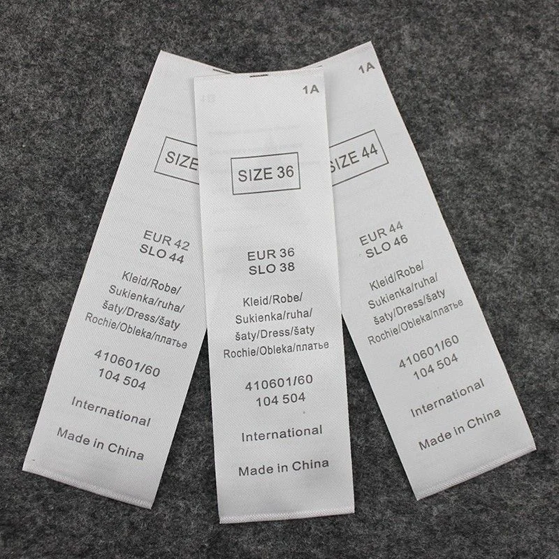 Three long fabric labels with printed sizes, product codes and origin information.