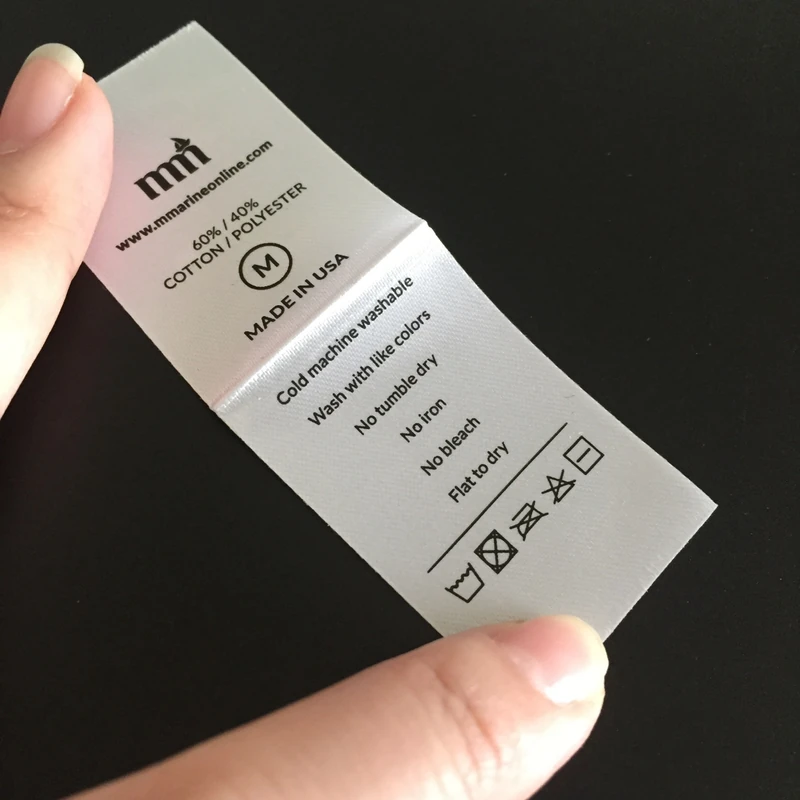 A cream fabric label showing printed washing symbols.