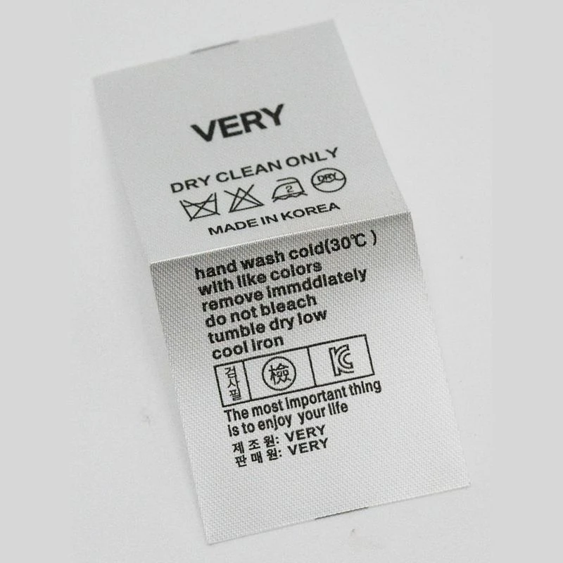 A white rectangular care label with printed symbols.