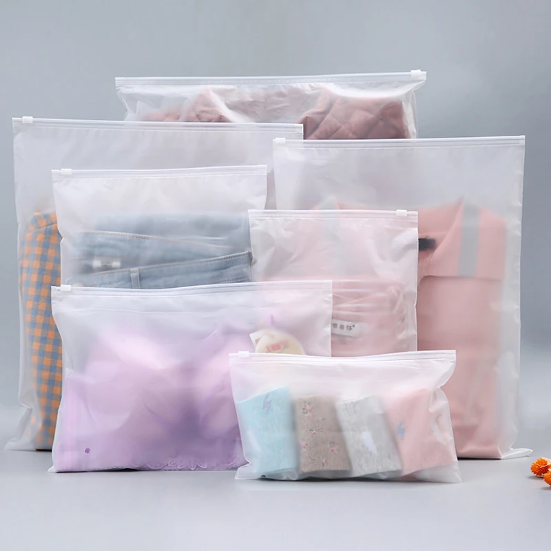 Frosted zipper garment bags in several sizes holding folded textiles.