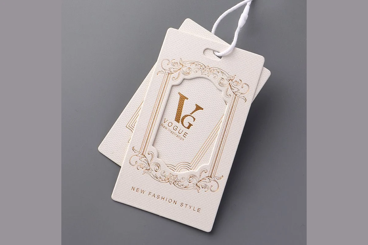 Cream hang tags with gold-colored artwork and white cords.