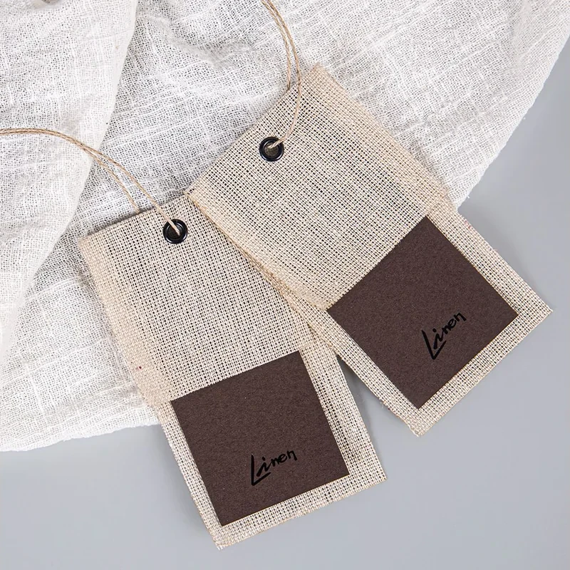 Two hang tags with a textured light surface and dark panels.