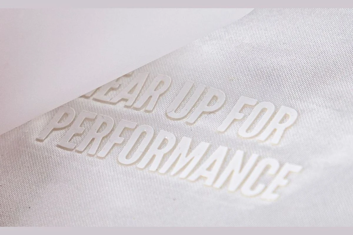 White raised lettering on white garment fabric.