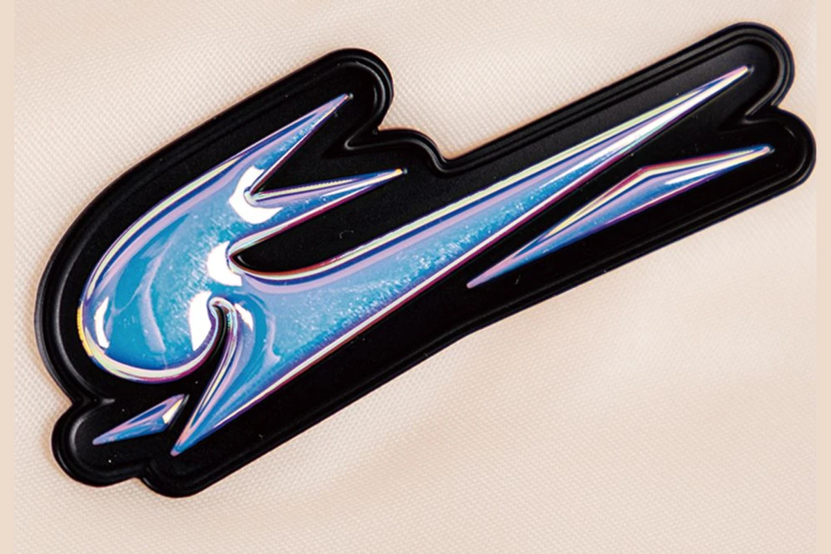 A raised black transfer sample with reflective blue and pink logo detail.