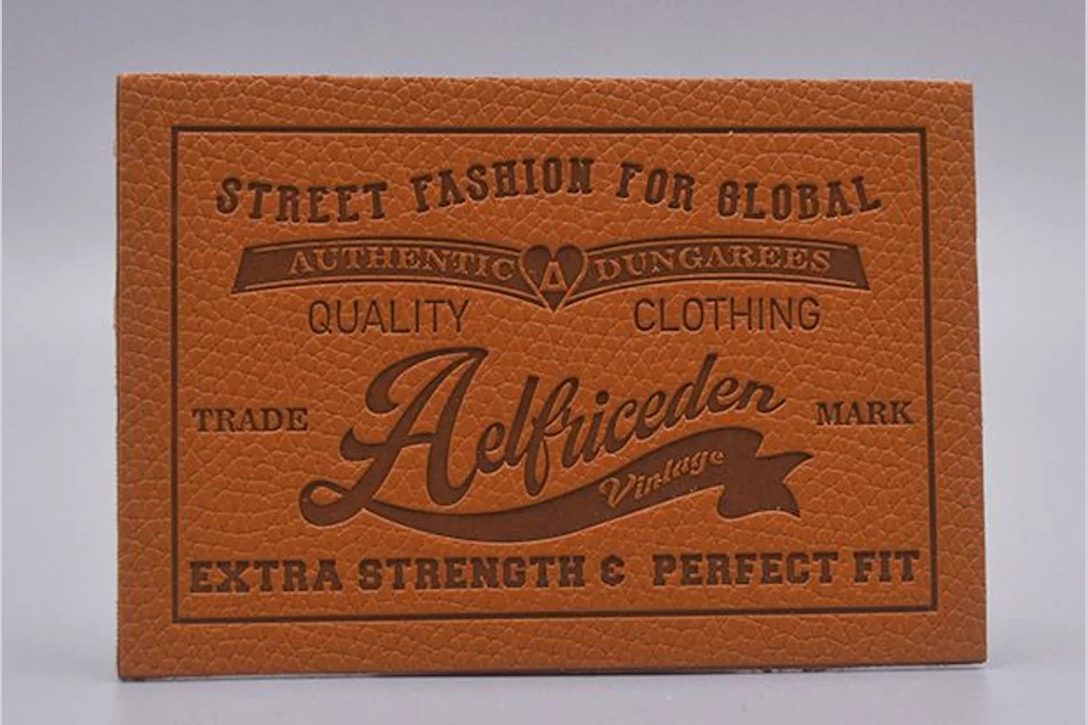 A finished brown label showing small text and impressed logo details.