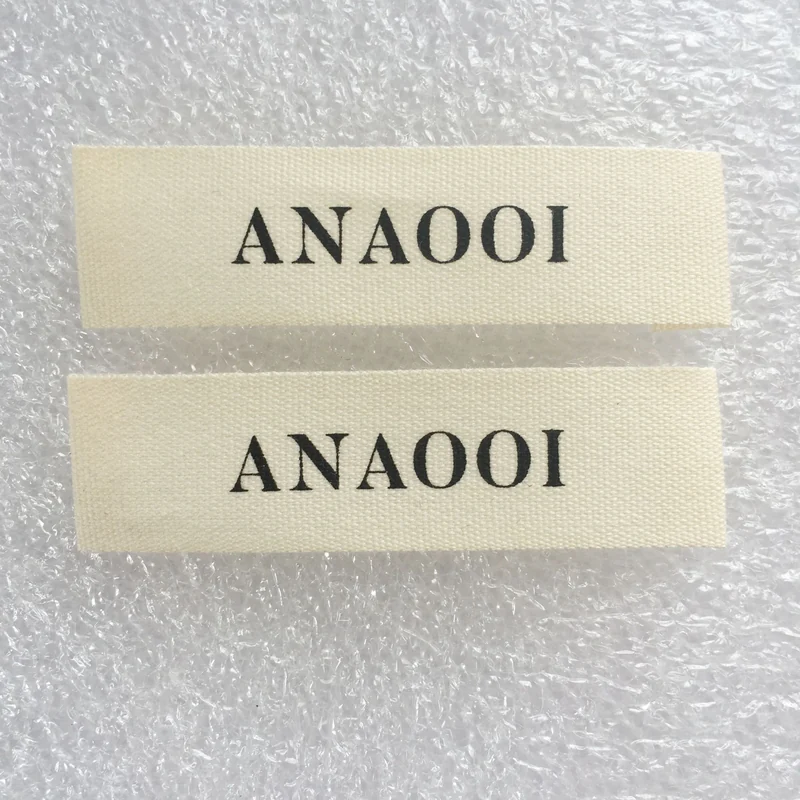 Cream cotton labels with black lettering.