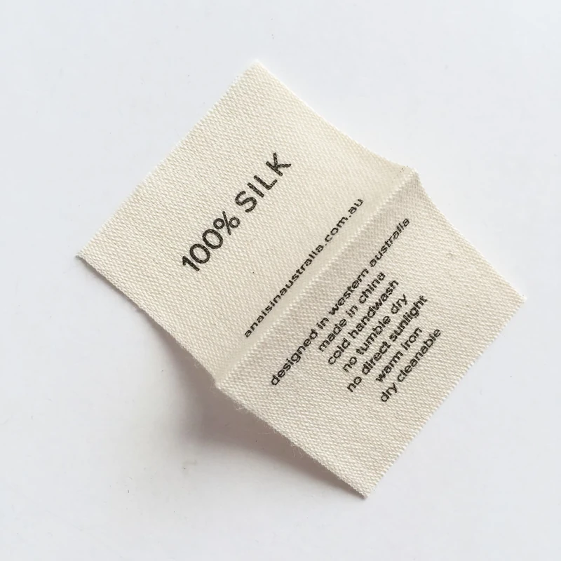 A folded cream printed label with composition and care information.