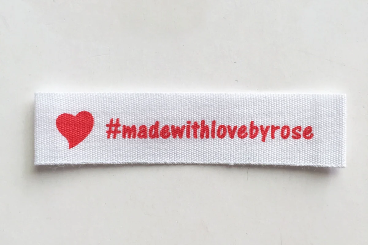 Close view of a printed label with a red heart and lettering.