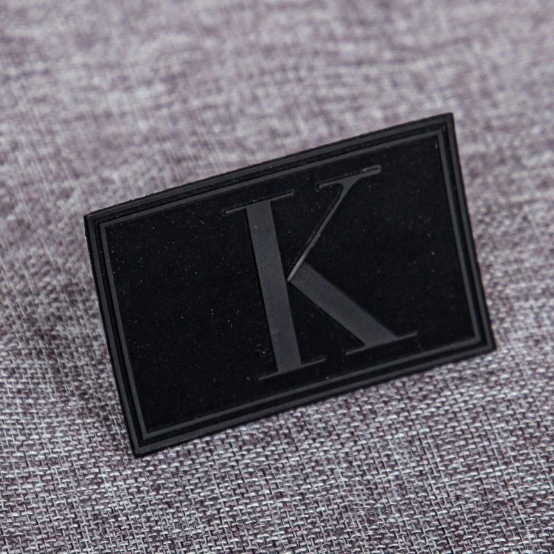A black rectangular molded label with a flat logo detail.