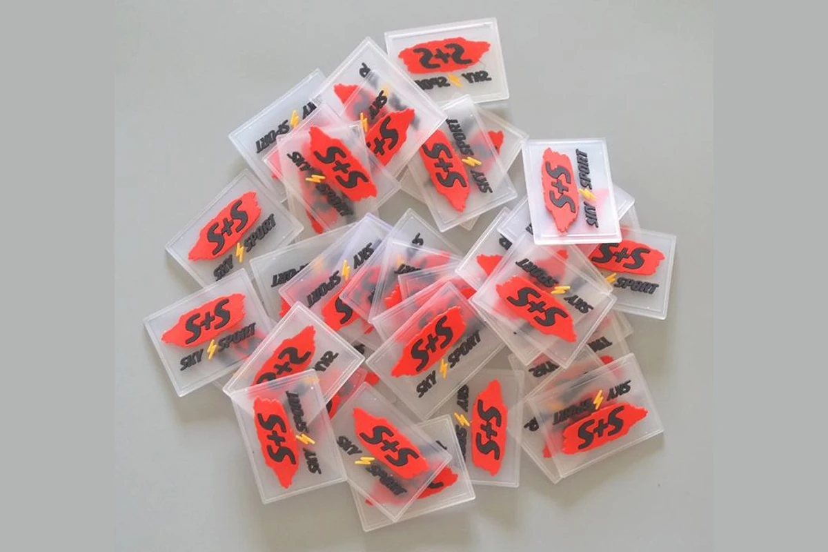 A grouped batch of clear rectangular PVC label samples with raised red and black designs.