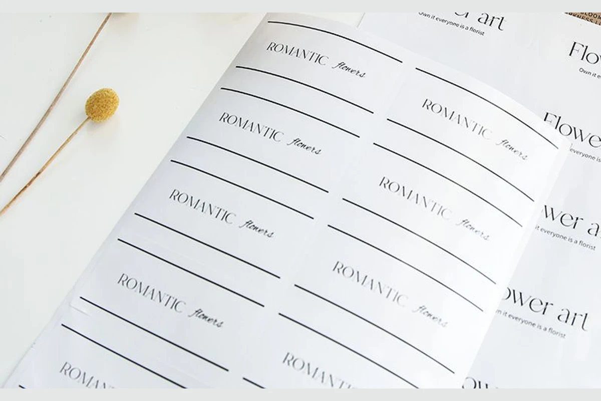 Close-up of white rectangular brand-sticker sheets with repeated printed messages.