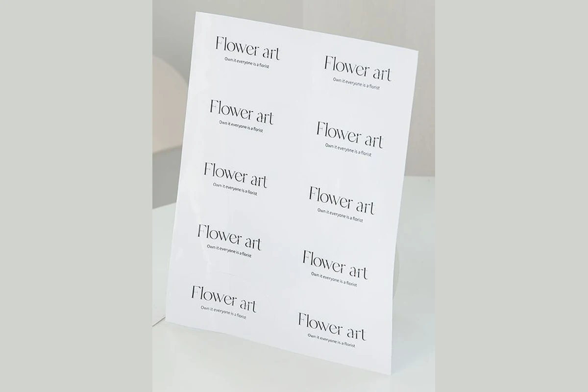 A white sheet of oval Flower art logo stickers standing on a table.