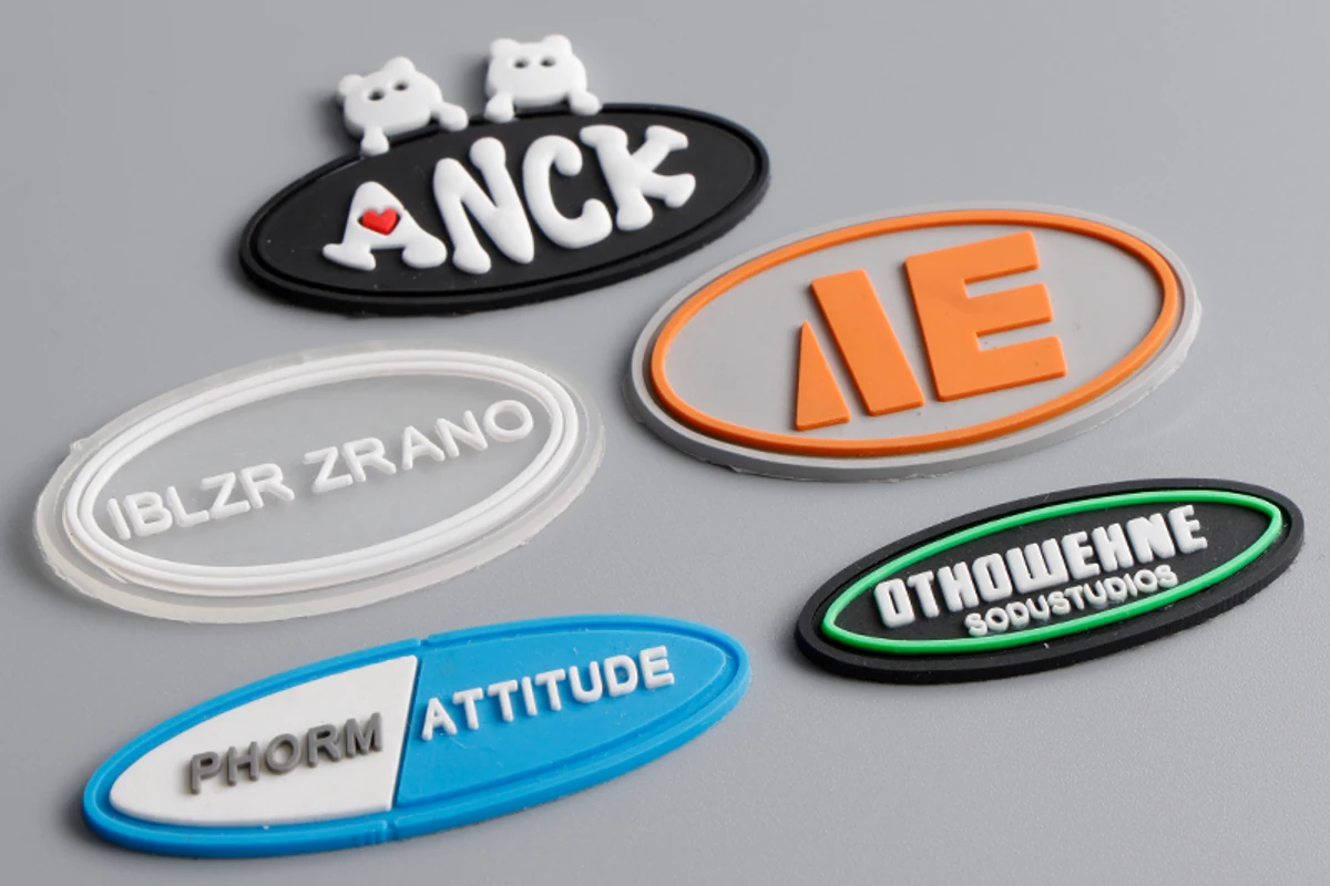 Molded oval logo label samples with contrasting borders and lettering.