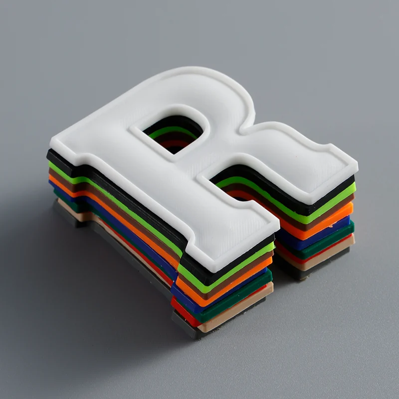A stack of molded letter labels with raised details.