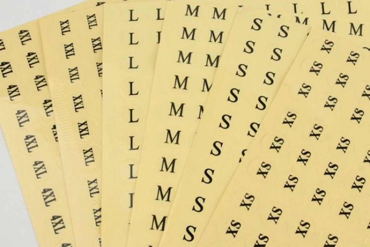 Rows of narrow rectangular stickers with letter sizes on yellow backing sheets.