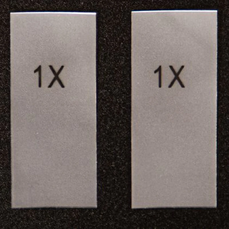 Two transparent rectangular size stickers with printed letter markings.