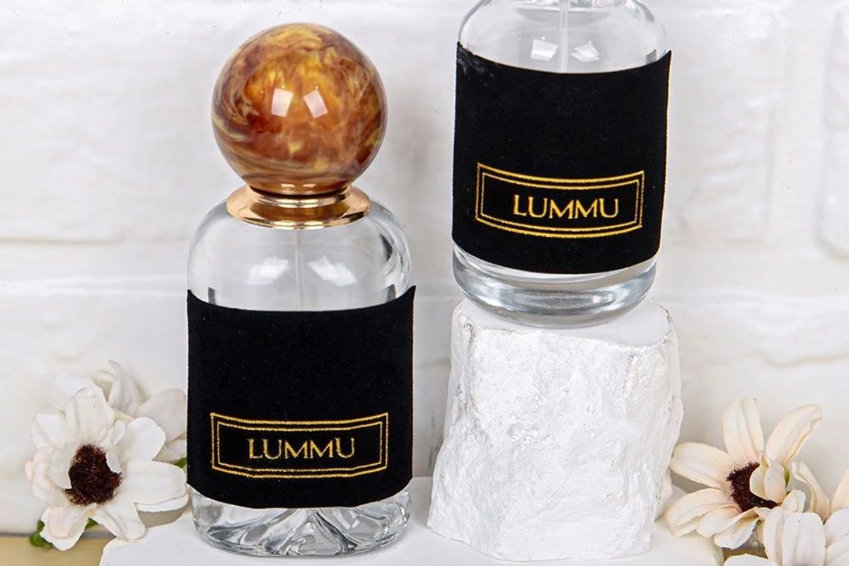 Close-up of black brand stickers with gold-colored lettering on two clear bottles.