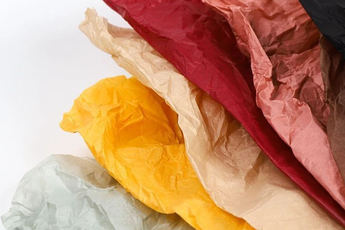 Crumpled tissue-paper samples in red, pink, yellow, cream and pale green.