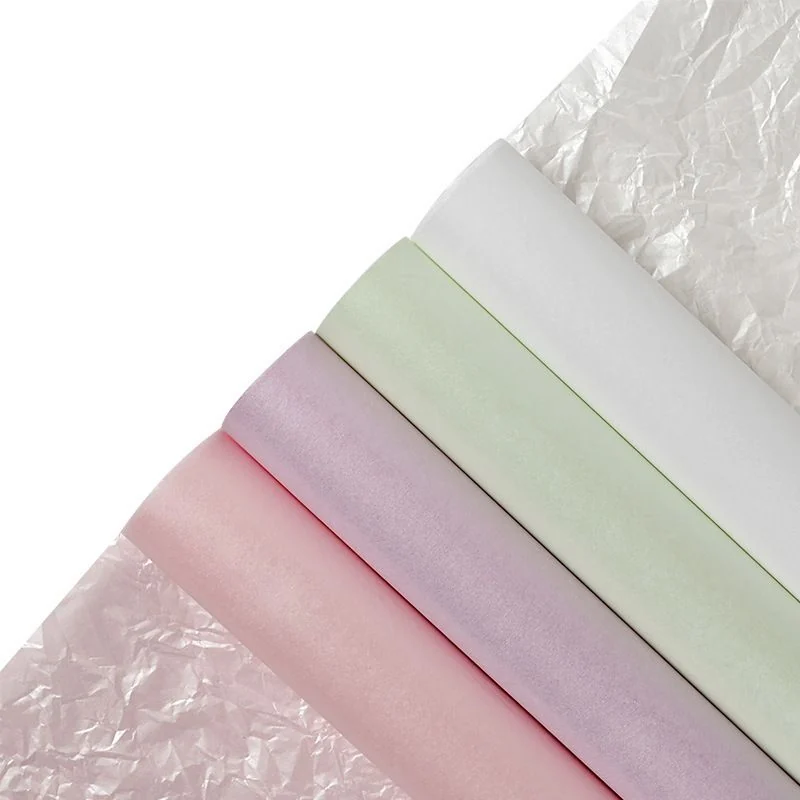Pastel wrapping-paper samples rolled beside crumpled paper.