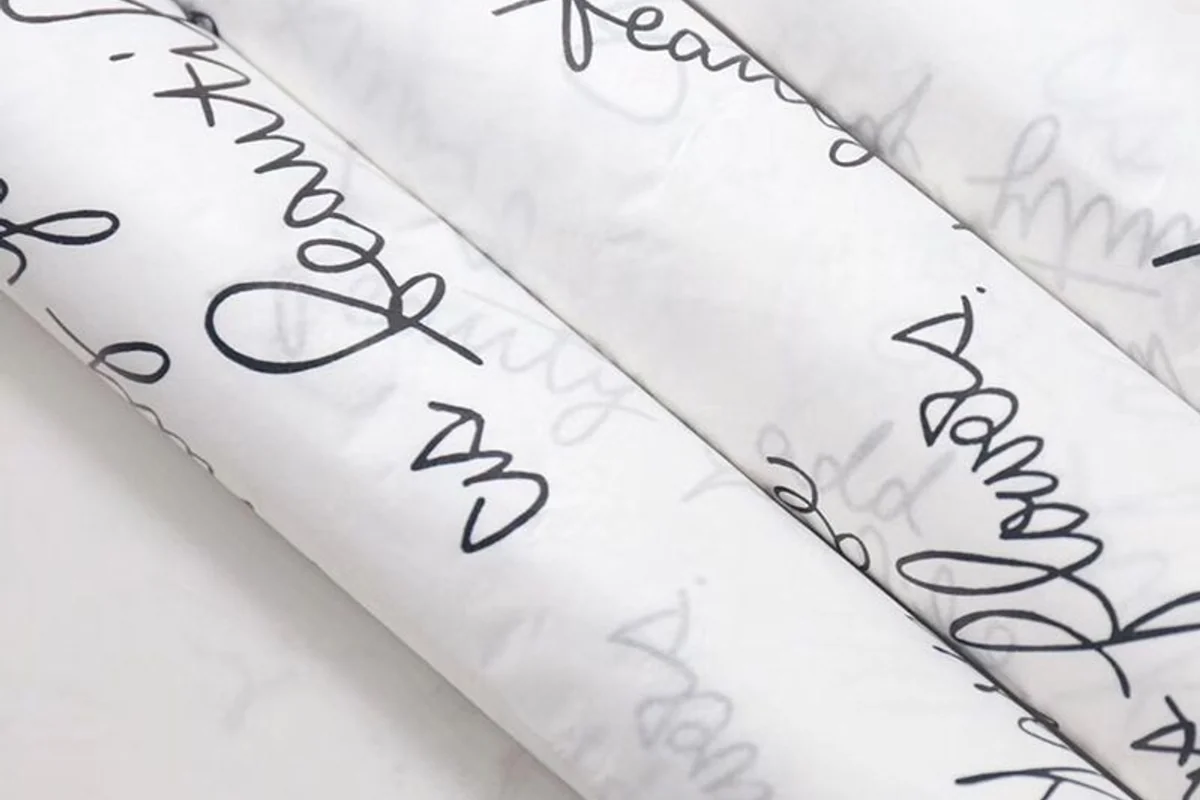 Translucent wrapping paper with repeated black script lettering.