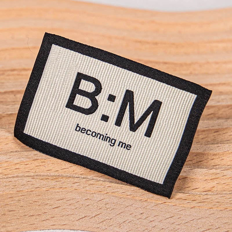 A black and cream woven label with bordered lettering.