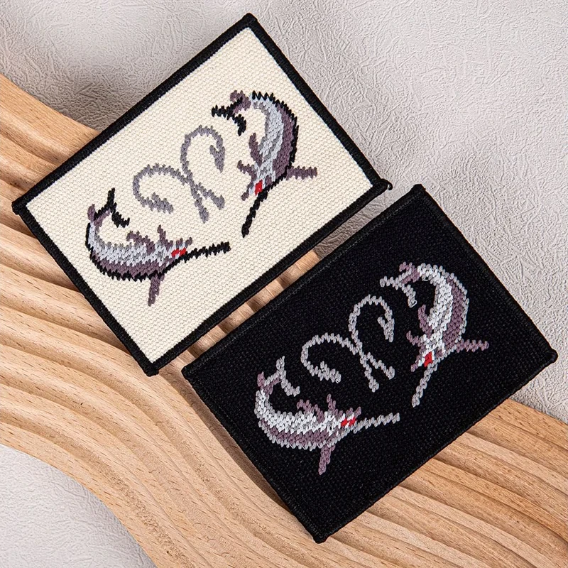 Black and cream woven labels with a multicolor motif.