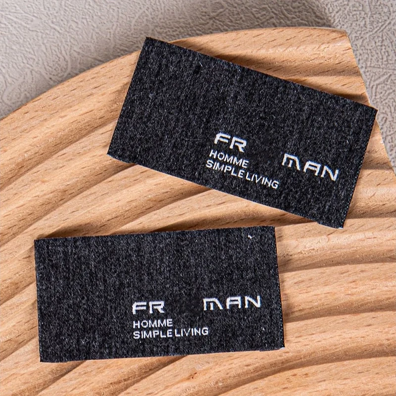 Black woven label samples viewed from different angles.
