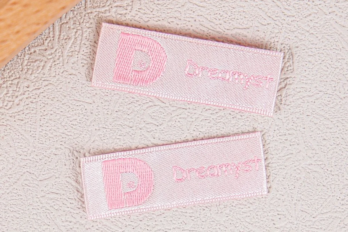 Pink woven labels with folded ends.