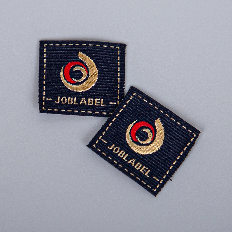 Finished navy woven labels with gold and red logo details.