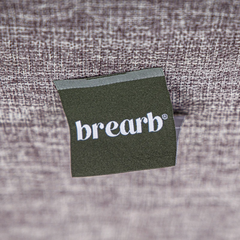 A green fabric brand label attached to textured cloth.