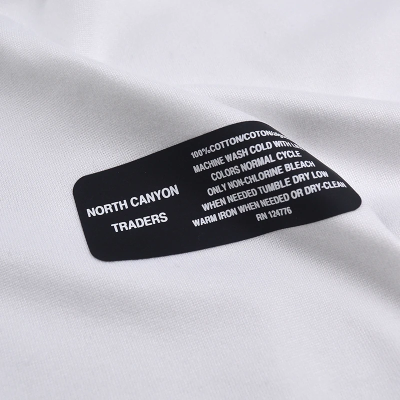 A black transfer label showing brand and garment information.