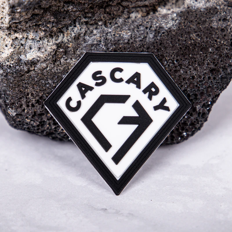 A black-and-white molded logo label with raised lettering and a shaped border.