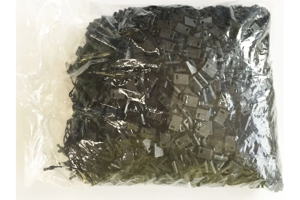 A packed batch of black tag cord fittings in a clear bag.